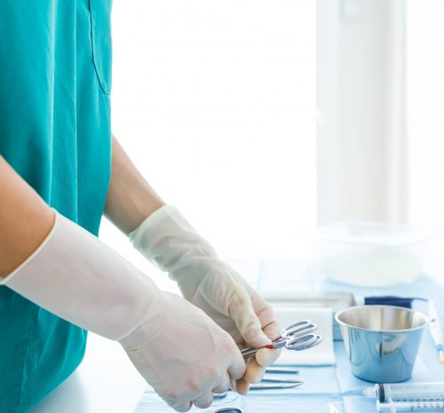 Portrait of doctor with many kind of medical equipment manage for to start operation in operating room.